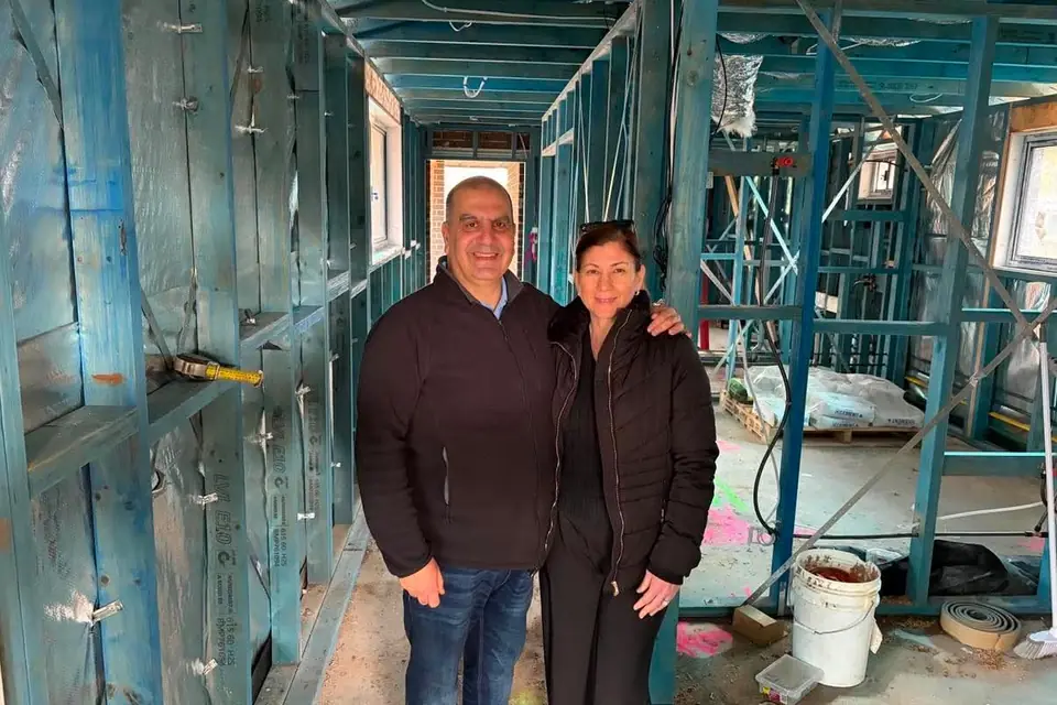 Two Links Property Finance clients standing inside the timber frame of their new home