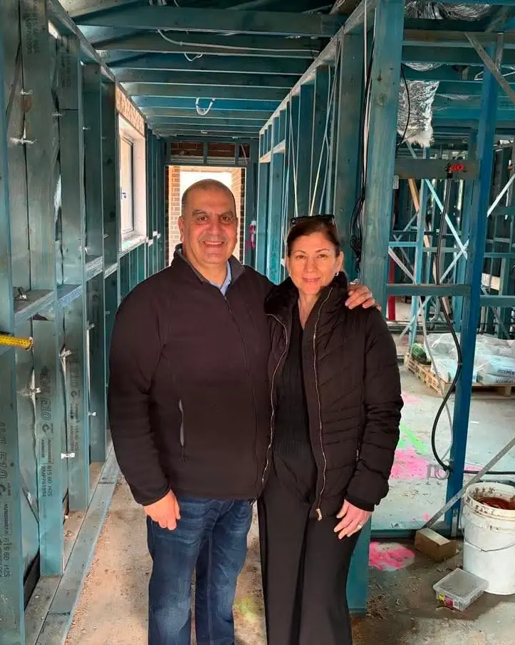 Two Links Property Finance clients standing inside the timber frame of their new home