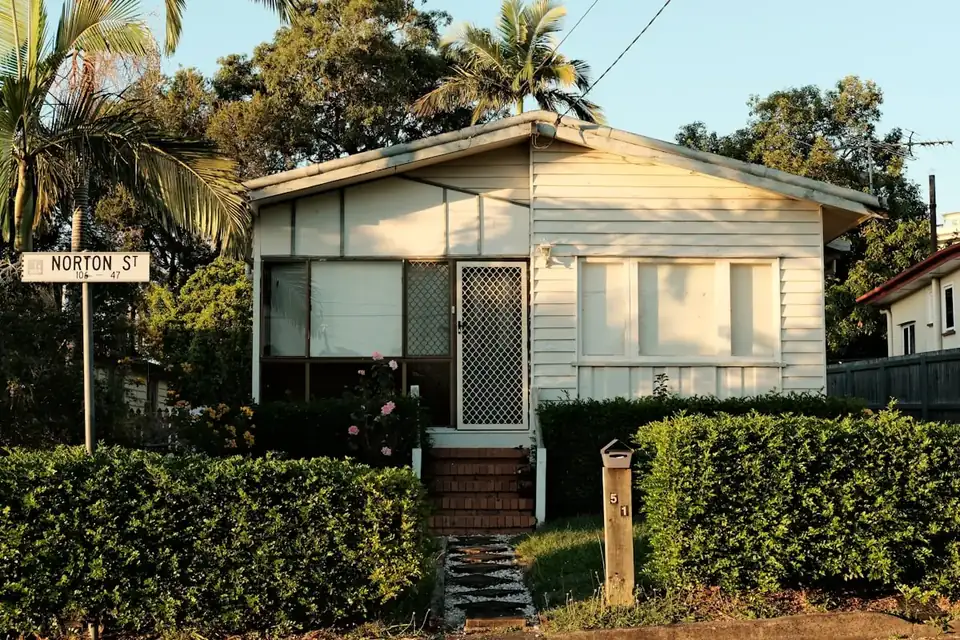 A corner cottage with a hedge