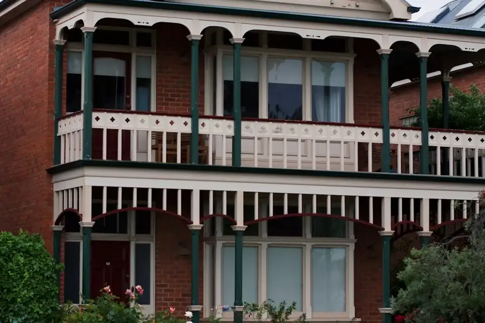 A terrace with an iron-lace balcony