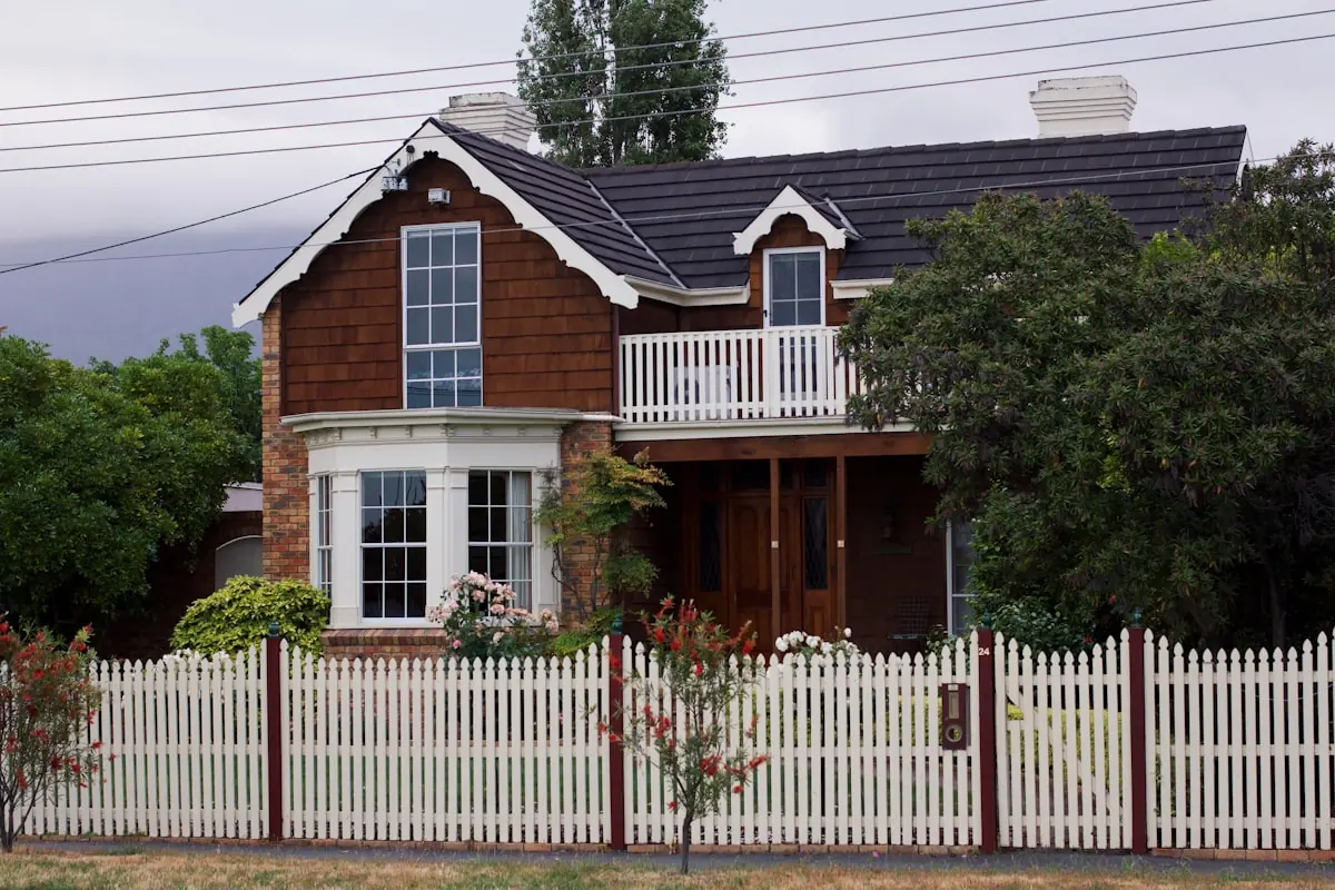 A family home behind a white picket fence