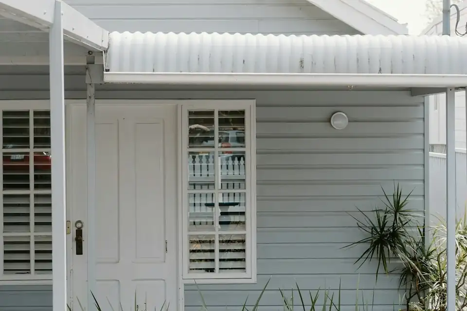 A weatherboard house with a white picket fence