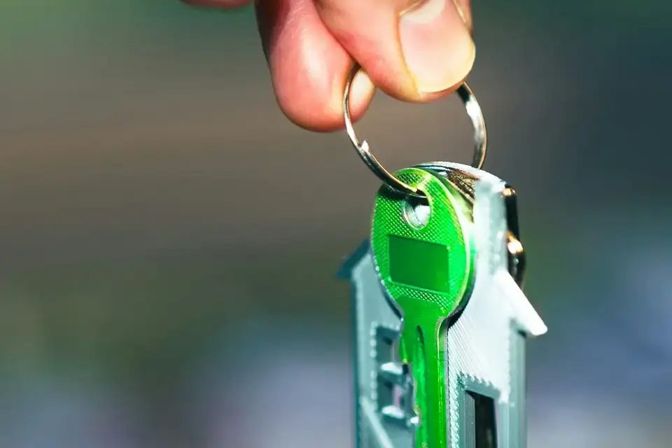 A house key on a green key ring